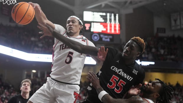 Texas Tech's guard Darrion Williams (5) and Cincinnati's forward Aziz Bandaogo (55) reach for the ball during the Big 12 basketball game, Saturday, Feb. 3, 2024, at United Supermarkets Arena.